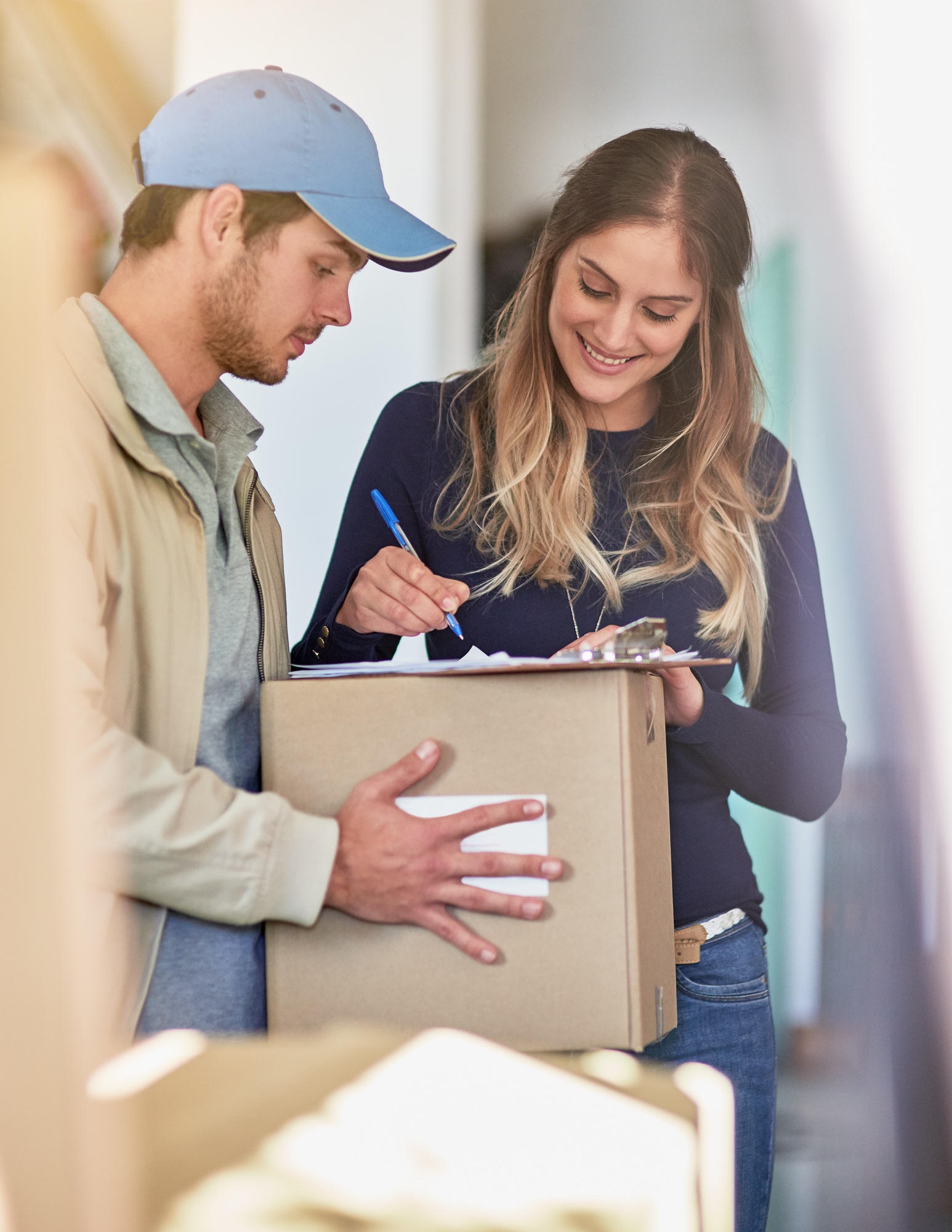 Shot of a delivery man making a delivery to a happy customer at her home